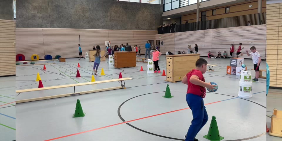 Schüler bewegen sich an mehreren sportstation-Parcours in der Sporthalle