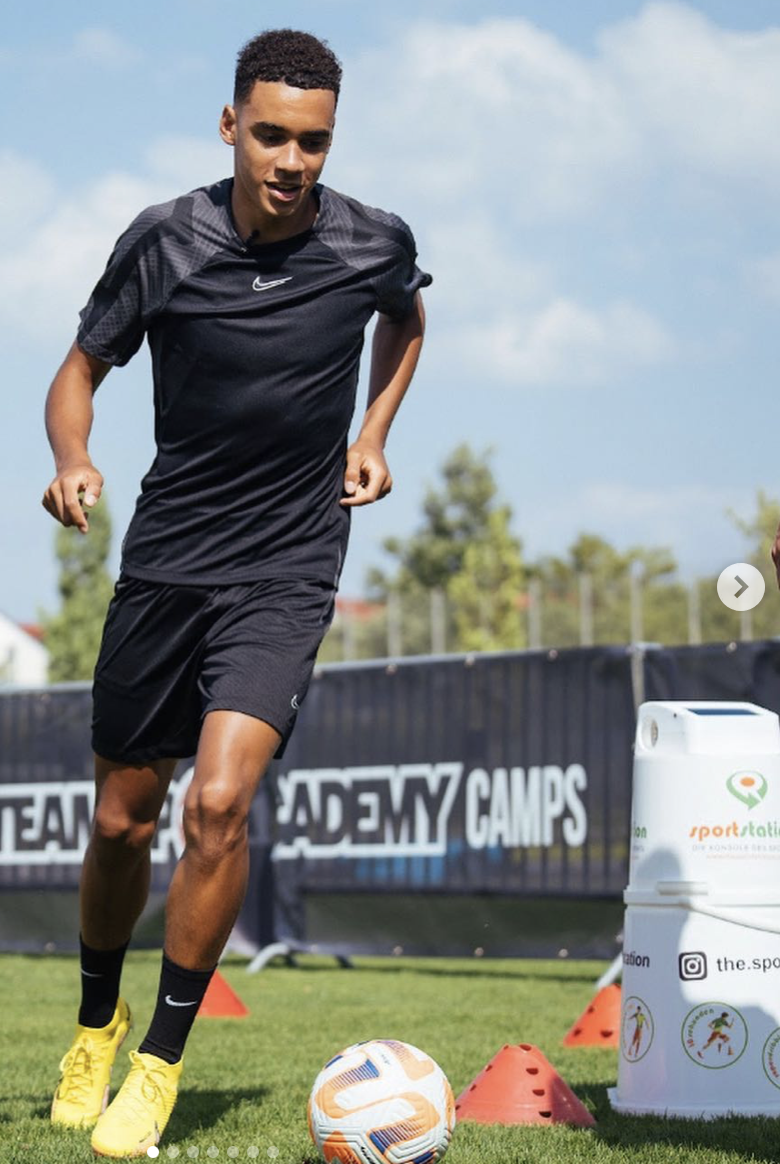 Jamal Musiala dribbelt mit dem Ball durch den sportstation-Parcours