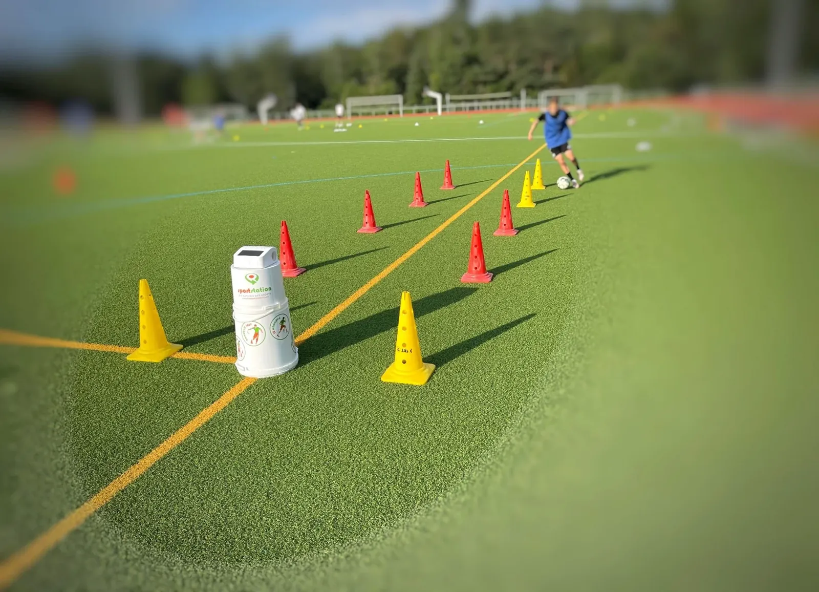 Dribbelparcours mit Hütchen und sportstation2 auf einem Sportplatz